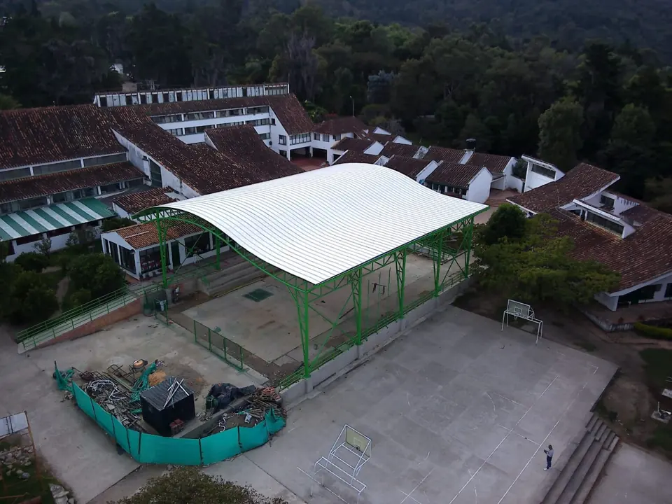 Vista aérea del coliseo escolar con cubierta curva blanca