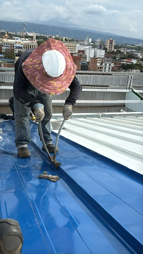 Instalador grafando la unión standing seam con herramienta manual
